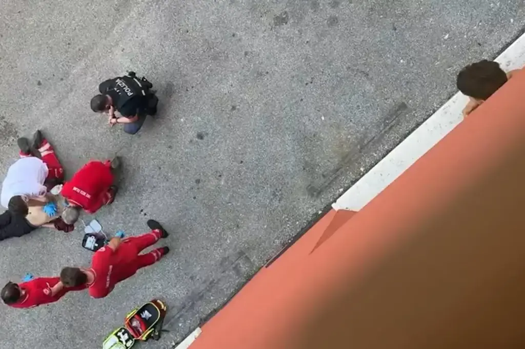 A still image from the video, one minute and 14 seconds long, showing Abderrahim Fakir on the ground still tied with zip ties on his ankles and arms behind his back. Around him are 4 Red Cross rescuers